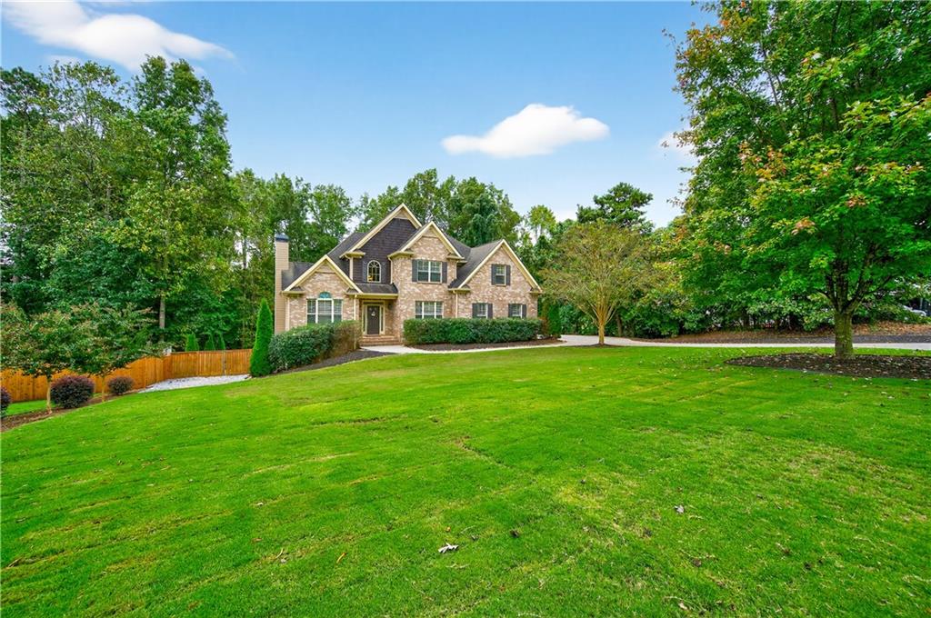 5250 Kendalls Way Cumming, GA 30041 - Photo 4 of 42 a front view of a house with yard and green space