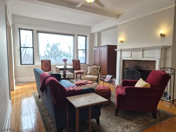a living room with furniture fireplace and a large window