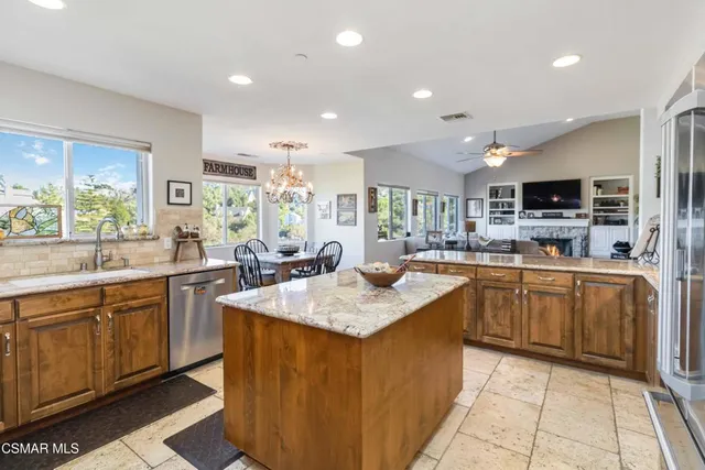 a kitchen with stainless steel appliances granite countertop a sink counter space cabinets and a large window