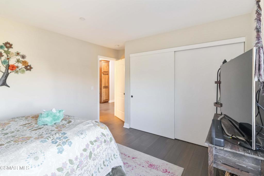 1308 Gonzales Road Simi Valley, CA 93063 - Photo 33 of 48 a bedroom with a bed wooden floor and a flat screen tv
