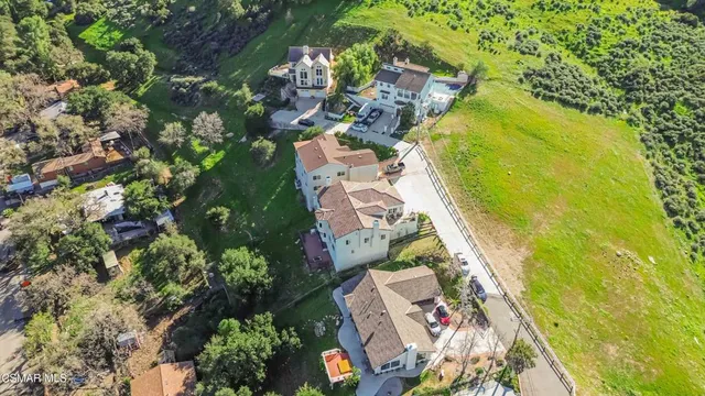 an aerial view of a house with a yard and lake view