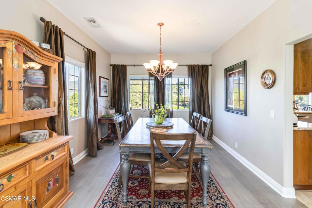 1308 Gonzales Road Simi Valley, CA 93063 - Photo 9 of 48 a dining room with wooden floor a chandelier a wooden table and chairs