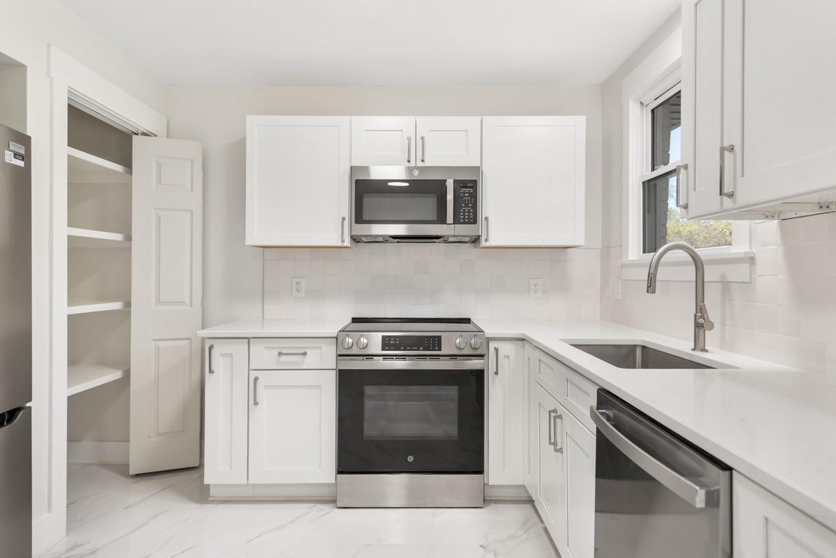 612 May Drive Madison, TN 37115 - Photo 16 of 46 a kitchen with white cabinets and stainless steel appliances