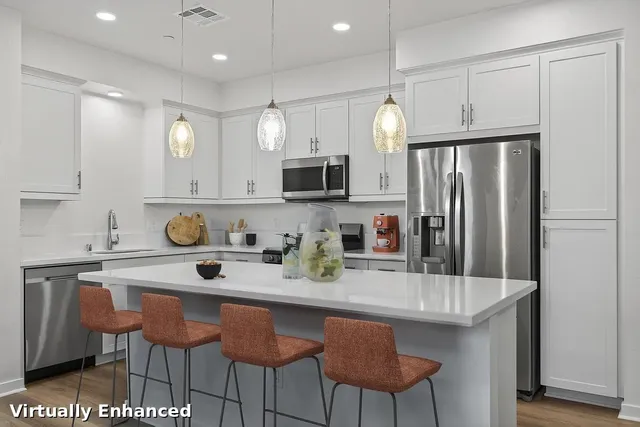 a kitchen with stainless steel appliances granite countertop a kitchen island a stove a table and chairs in it