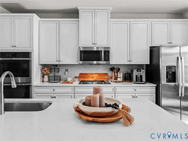 a kitchen with stainless steel appliances granite countertop a refrigerator sink and cabinets