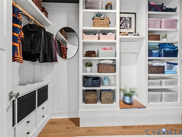 a view of walk in closet with clothes and shoes