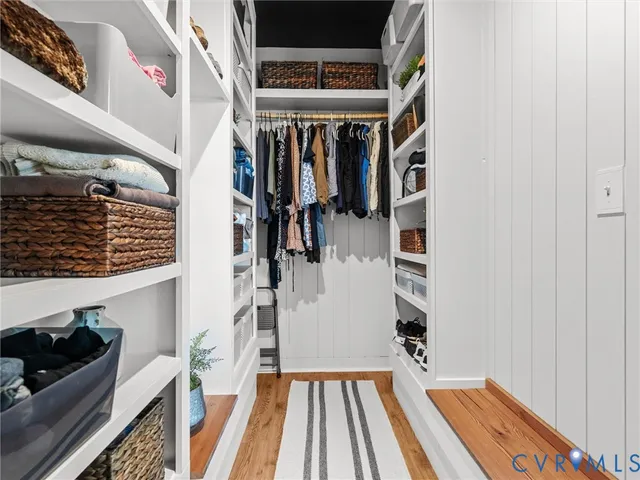 a view of an empty room with wooden floor and a fireplace