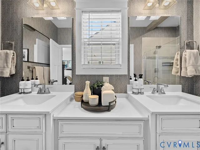 a view of a hallway with wooden floor and a bathroom