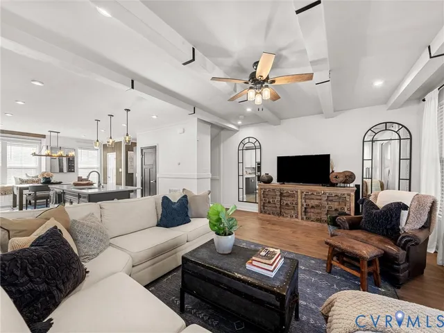 a living room with furniture a flat screen tv and kitchen view