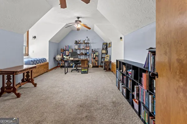 a living room with furniture and a book shelf