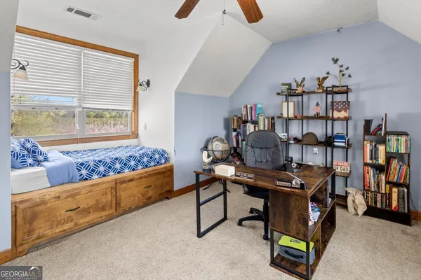 a view of a workspace with furniture and a book shelf