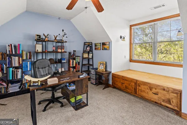 a view of a workspace with furniture and a window