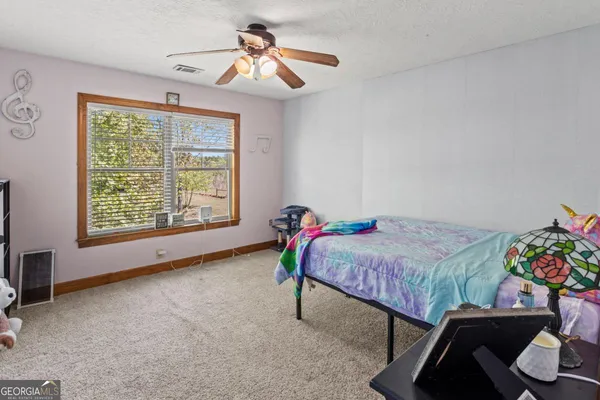 a bedroom with a bed a dresser and a window
