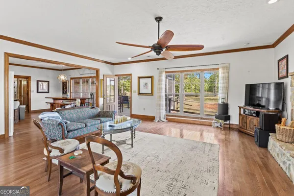 a living room with furniture a flat screen tv and a large window