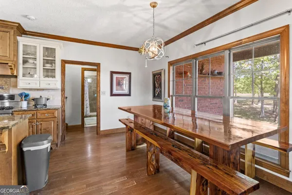 a dining room with furniture a chandelier and wooden floor