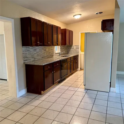 a kitchen with stainless steel appliances granite countertop a refrigerator and a stove top oven