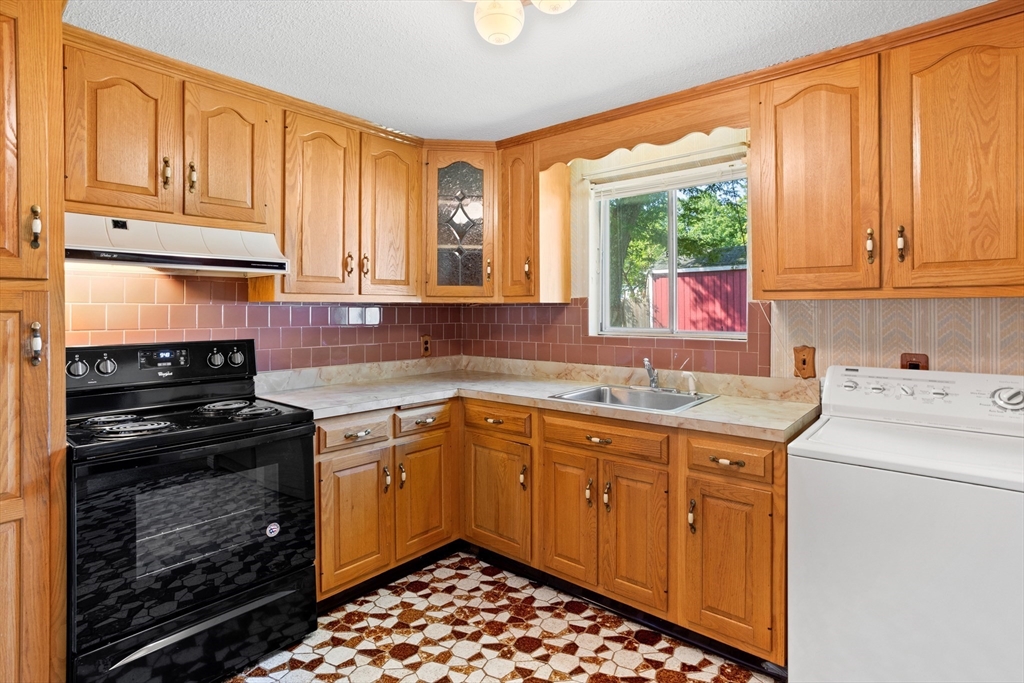 52 Brooks Street Maynard, MA 01754 - Photo 11 of 28 a kitchen with a stove sink and cabinets