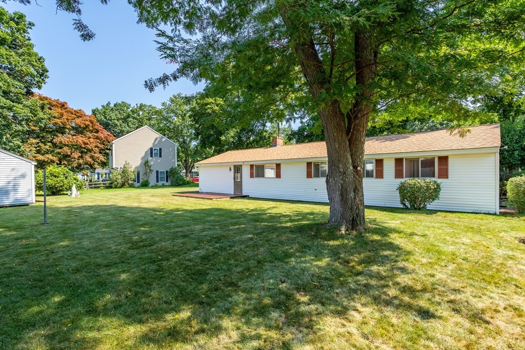 52 Brooks Street Maynard, MA 01754 - Photo 25 of 28 a backyard of a house with large trees and entertaining space