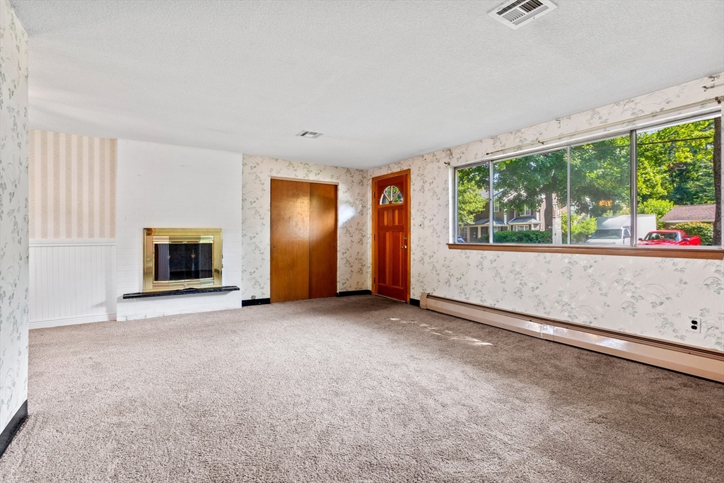 52 Brooks Street Maynard, MA 01754 - Photo 5 of 28 an empty room with windows and fireplace
