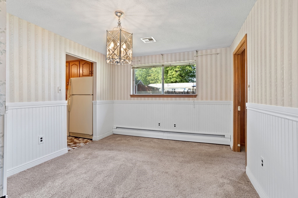 52 Brooks Street Maynard, MA 01754 - Photo 8 of 28 an empty room with windows and chandelier
