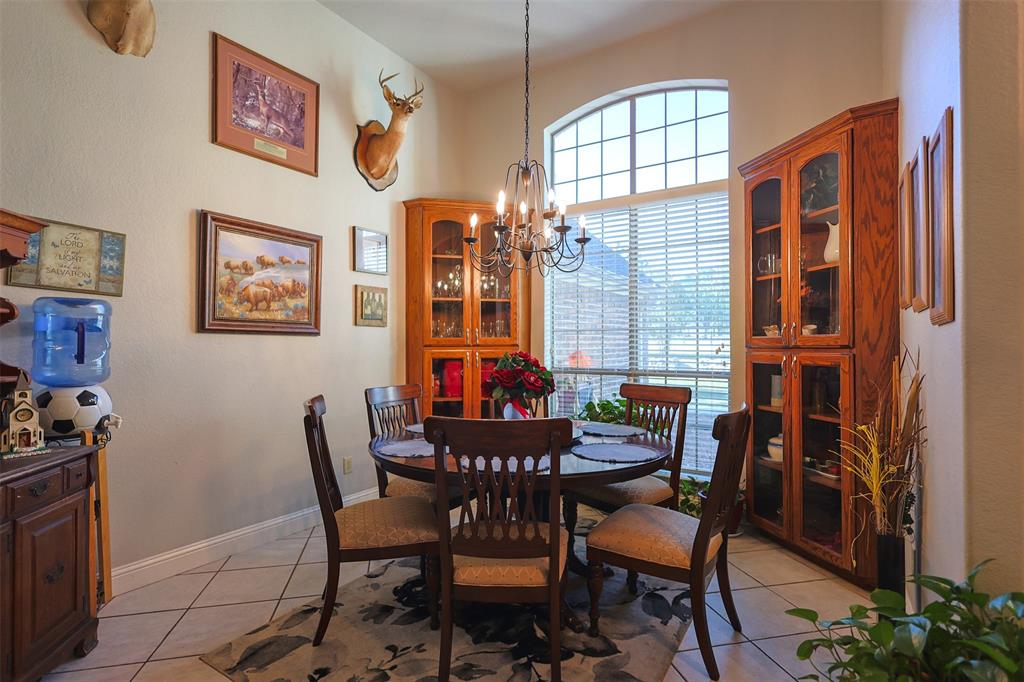 111 Deerfield Road Paradise, TX 76073 - Photo 14 of 39 Dining space with light tile patterned floors and a chandelier
