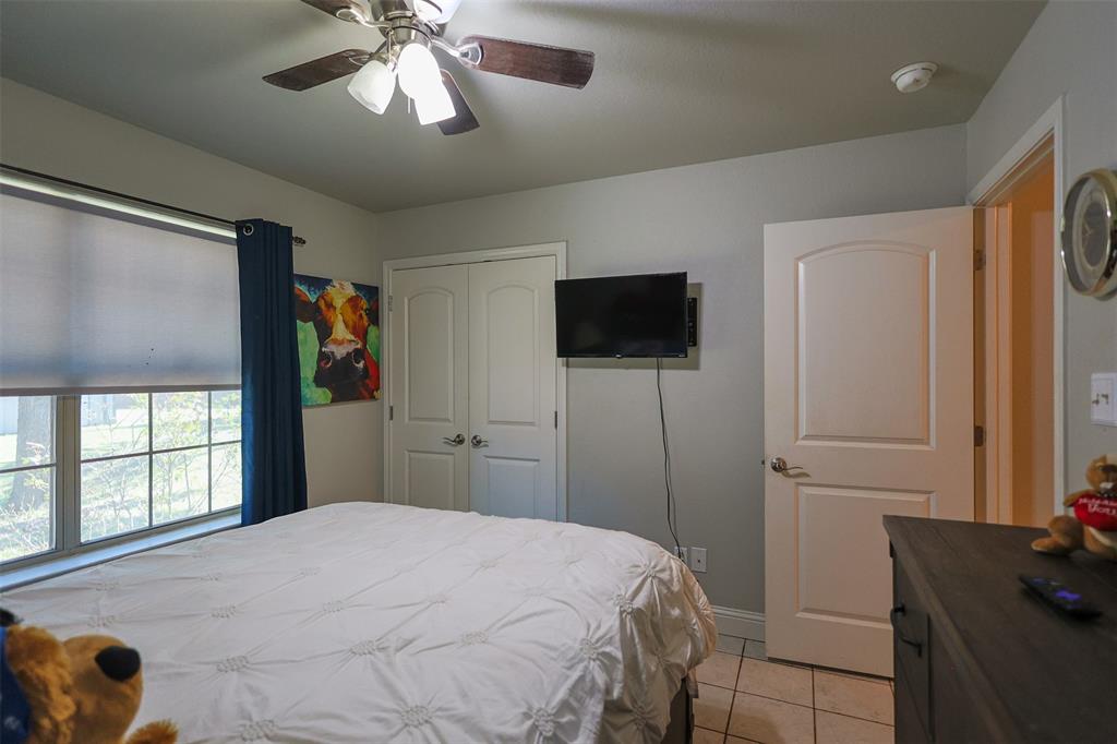 111 Deerfield Road Paradise, TX 76073 - Photo 21 of 39 Bedroom with light tile patterned flooring, ceiling fan, and a closet