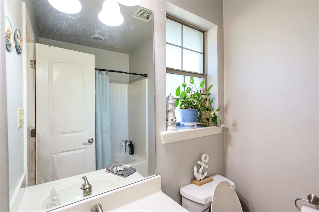 111 Deerfield Road Paradise, TX 76073 - Photo 22 of 39 Full bathroom with a textured wall, vanity, and shower / bath combination with curtain