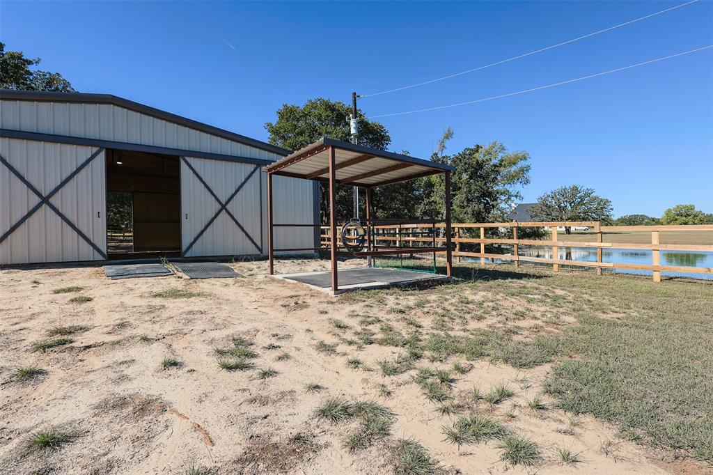 111 Deerfield Road Paradise, TX 76073 - Photo 32 of 39 View of yard featuring a water view, an outbuilding, and an exterior structure