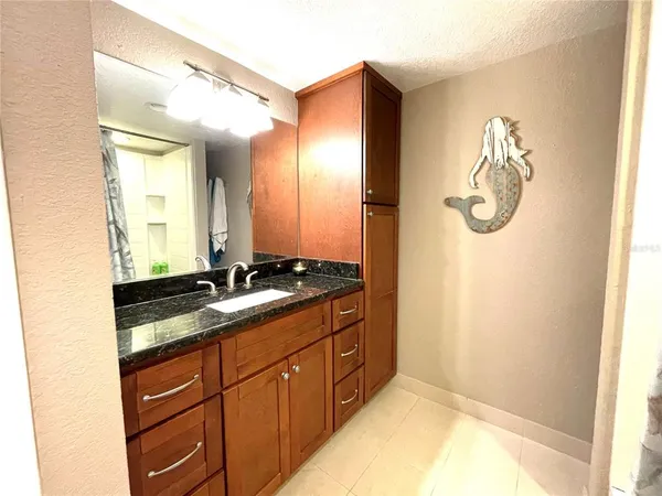 a bathroom with a granite countertop sink and a mirror