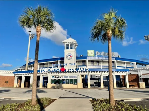 a front view of multi story residential apartment building with yard and sign board