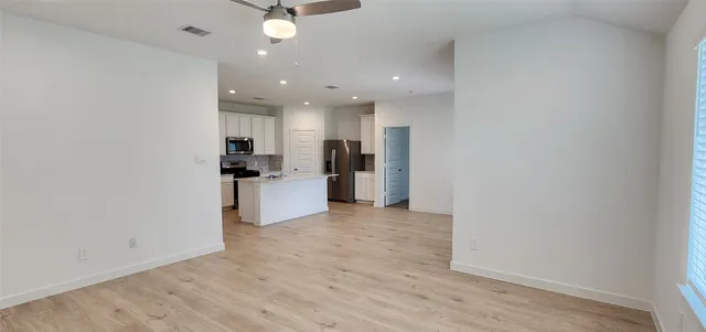 a view of a kitchen with a sink and refrigerator