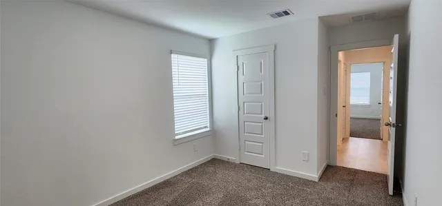 an empty room with windows and closet