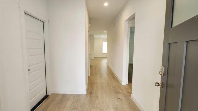 a view of a hallway with wooden floor