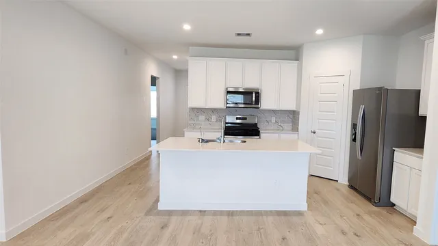 a kitchen with stainless steel appliances a refrigerator and a stove top oven