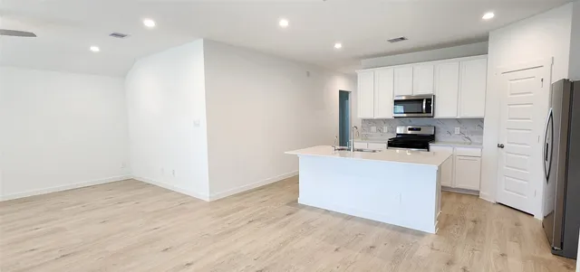 a kitchen with stainless steel appliances a refrigerator and a stove top oven