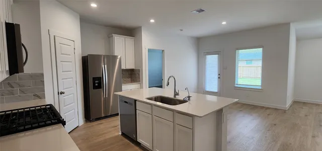 a kitchen that has a refrigerator and a sink