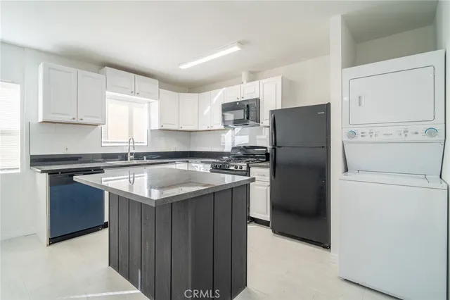 a kitchen with a refrigerator sink and cabinets