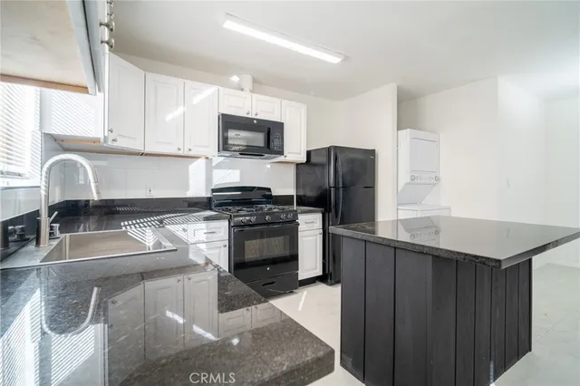 a kitchen with stainless steel appliances granite countertop a sink stove refrigerator and a window