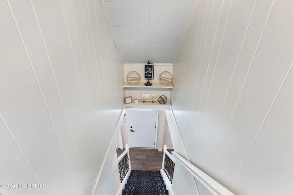 a hallway with stairs and wooden floor
