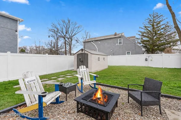 a view of a chairs and table in the back yard of the house