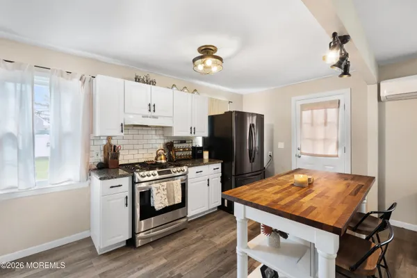 a kitchen with a stove a refrigerator and a stove top oven