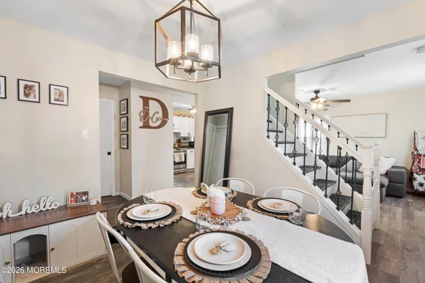a view of a dining room with furniture a chandelier and wooden floor