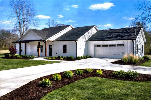 a view of a house with a yard and pathway