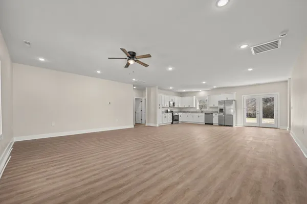 an empty room with wooden floor and windows