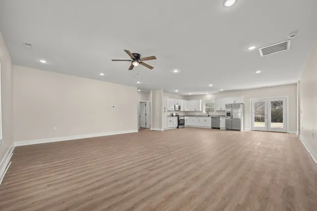 an empty room with wooden floor and windows