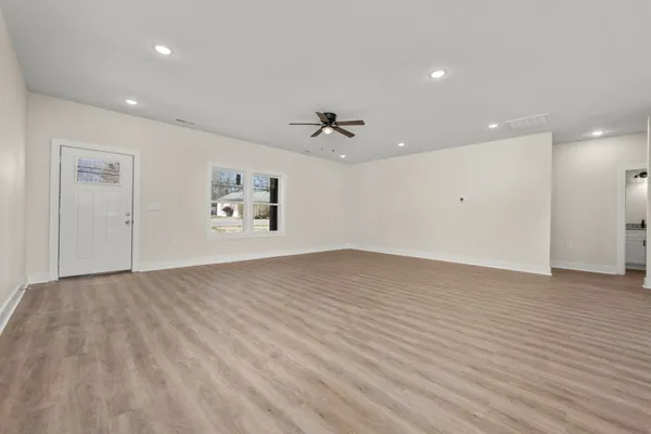 an empty room with fan and windows