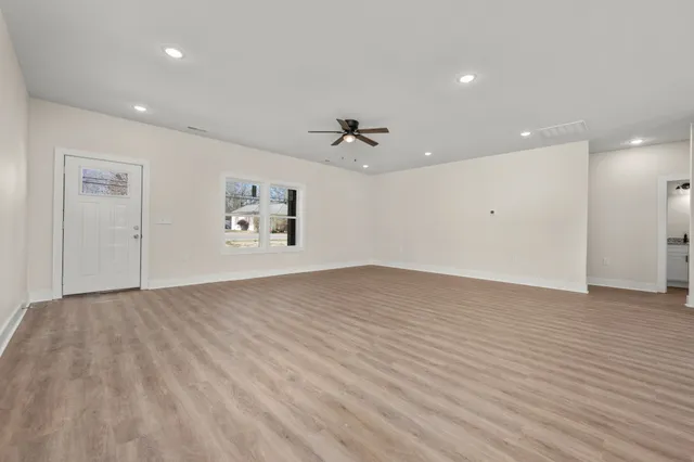 an empty room with fan and windows