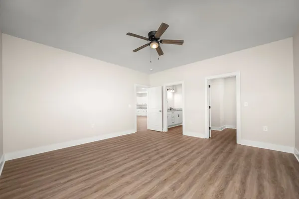a view of a livingroom with a ceiling fan & wooden floor