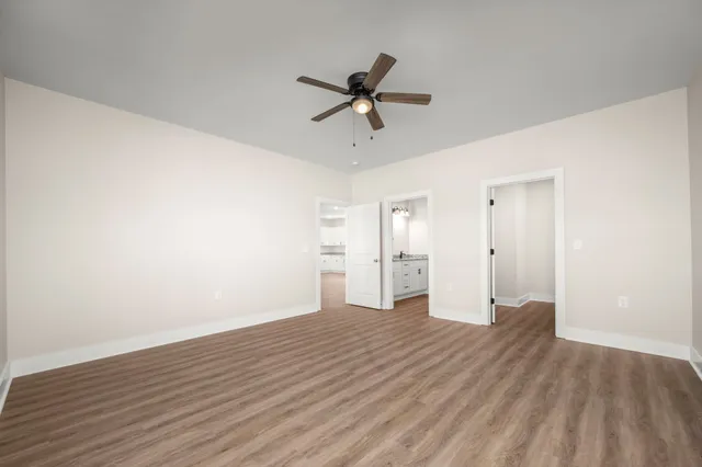 a view of a livingroom with a ceiling fan & wooden floor
