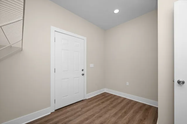 a view of an empty room with wooden floor